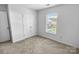 An additional bedroom includes a closet, plush carpet, and natural light from the window at 8829 Michaw Ct, Charlotte, NC 28269
