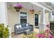 Cozy porch with outdoor seating, hanging plants, and decorative floral landscaping at 8829 Michaw Ct, Charlotte, NC 28269