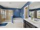 This bathroom features blue walls, a shower, and a separate tub for a luxurious experience at 8923 Happiness Rd, Harrisburg, NC 28075