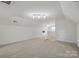 A large, carpeted bonus room with bright, neutral paint and adjustable track lighting at 8923 Happiness Rd, Harrisburg, NC 28075