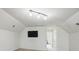 An upstairs bonus room with neutral carpet, white walls and a TV mounted on the wall at 8923 Happiness Rd, Harrisburg, NC 28075
