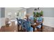 Dining room with wood floors, blue upholstered chairs, and a view to the living room at 8923 Happiness Rd, Harrisburg, NC 28075