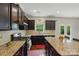Spacious kitchen with dark cabinets, granite countertops, and a view of the backyard at 8923 Happiness Rd, Harrisburg, NC 28075