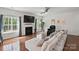 Cozy living room featuring hardwood floors, a fireplace, and ample natural light at 8923 Happiness Rd, Harrisburg, NC 28075