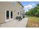 An outdoor patio with wicker furniture and a view of the manicured yard and privacy fence at 8923 Happiness Rd, Harrisburg, NC 28075