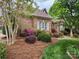 Charming brick house with blue shutters and flowering bushes in a well-manicured lawn at 915 Houston Dr, Monroe, NC 28110