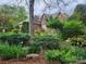 A beautiful brick home is set back from the street and adorned with lush landscaping and mature trees at 915 Houston Dr, Monroe, NC 28110