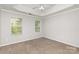 Neutral bedroom with two windows, ceiling fan, and tray ceiling detail at 9419 Isaac Hunter Dr, Charlotte, NC 28214