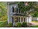 Charming two-story home with vinyl siding, black shutters, covered front porch and well-manicured landscaping at 9419 Isaac Hunter Dr, Charlotte, NC 28214