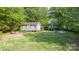 Backyard featuring grassy space, trees, outbuilding, a playground, and a small pool at 103 Woodwinds St, Locust, NC 28097