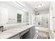 Bathroom with shower and updated grey vanity with granite countertops and hardware at 103 Woodwinds St, Locust, NC 28097