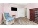 Bedroom featuring hardwood floors, pink walls, and a cozy chair for relaxation and comfort at 103 Woodwinds St, Locust, NC 28097