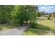 Gravel driveway, lined by green grass and trees, leading to the home at 103 Woodwinds St, Locust, NC 28097