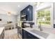 Updated kitchen showcasing blue cabinets, stainless steel appliances, modern countertops, and natural light at 103 Woodwinds St, Locust, NC 28097