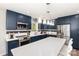 Modern kitchen showcasing blue cabinets, stainless steel appliances, a large island, and stylish pendant lighting at 103 Woodwinds St, Locust, NC 28097