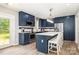 Modern kitchen with navy cabinets, stainless steel appliances, and white countertop island with seating at 103 Woodwinds St, Locust, NC 28097