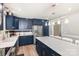 Bright kitchen features stainless steel appliances, navy cabinets and a large island with quartz countertops at 103 Woodwinds St, Locust, NC 28097
