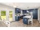 Modern kitchen featuring blue cabinets, stainless steel appliances, white countertops, and access to the backyard at 103 Woodwinds St, Locust, NC 28097