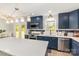 Stylish kitchen featuring blue cabinets, stainless steel appliances, a large island, and modern lighting fixtures at 103 Woodwinds St, Locust, NC 28097