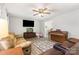 Open-concept living room with neutral walls, laminate flooring, a ceiling fan, and entertainment area at 103 Woodwinds St, Locust, NC 28097