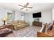Cozy living room showcasing neutral walls, a ceiling fan, laminate flooring, and natural light from windows at 103 Woodwinds St, Locust, NC 28097