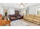Inviting living room featuring comfortable seating, neutral walls, a ceiling fan, and a decorative rug at 103 Woodwinds St, Locust, NC 28097