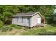 Exterior view of detached outbuilding with door, window, and partial porch at 103 Woodwinds St, Locust, NC 28097