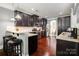 Open kitchen with granite countertops, stainless steel appliances, and dark wood cabinets plus bar seating at 10328 Lemington Dr, Mint Hill, NC 28227