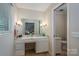 Bathroom vanity with marble countertop, classic sconces, and an adjacent toilet room at 1058 General Hoke Dr, Lincolnton, NC 28092