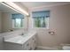 Well-lit bathroom with a white vanity, a large mirror, and a serene window view at 1058 General Hoke Dr, Lincolnton, NC 28092
