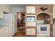 Kitchen showing a brick accent wall, white appliances, and view into an adjoining room with a fireplace at 1058 General Hoke Dr, Lincolnton, NC 28092