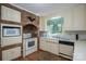 Traditional kitchen featuring brick accents, white appliances, ample cabinet space and a bright window at 1058 General Hoke Dr, Lincolnton, NC 28092