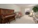 Elegant living room featuring a vintage piano, plush armchairs, and a view into the formal dining area at 1058 General Hoke Dr, Lincolnton, NC 28092