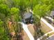 An aerial view of a two-story home with an extended driveway surrounded by lush greenery and tall trees at 11215 Dappled Light Trl, Charlotte, NC 28227