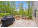 Backyard wooden deck featuring grill, and green landscape views at 11215 Dappled Light Trl, Charlotte, NC 28227