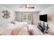 Bedroom with neutral colors, ceiling fan, large window, and TV with stand at 11215 Dappled Light Trl, Charlotte, NC 28227