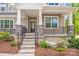 Close up view of front porch with stone pillar bases, black metal railing, and attractive landscaping at 11215 Dappled Light Trl, Charlotte, NC 28227