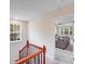Bright hallway with wood railing leading to a cozy living room with a comfortable gray sectional at 11215 Dappled Light Trl, Charlotte, NC 28227