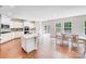 Open concept kitchen with center island, white cabinets, and stainless appliances next to the dining area and deck access at 11215 Dappled Light Trl, Charlotte, NC 28227