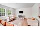 Bright living room with hardwood floors, neutral furniture, and a modern electric fireplace at 11215 Dappled Light Trl, Charlotte, NC 28227