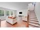 Spacious living room featuring hardwood floors, stairs to the upper level and lots of natural light at 11215 Dappled Light Trl, Charlotte, NC 28227