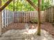Fenced backyard with shade trees, greenery, a small garden bed, and stepping stone walkway at 1203 Maple Shade Ln, Charlotte, NC 28270