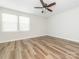 Light-filled bedroom with wood floors, ceiling fan, and a large window at 1203 Maple Shade Ln, Charlotte, NC 28270