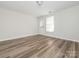 Empty bedroom featuring neutral walls, a back door, and wood-look flooring at 1203 Maple Shade Ln, Charlotte, NC 28270
