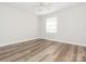 This bright bedroom features wood-look flooring, neutral walls, and a ceiling fan at 1203 Maple Shade Ln, Charlotte, NC 28270