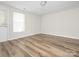 Empty bedroom featuring neutral walls, a back door, and wood-look flooring at 1203 Maple Shade Ln, Charlotte, NC 28270