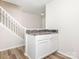 Neutral-toned kitchen with modern wood floors and a gray and white countertop bar for extra seating and serving space at 1203 Maple Shade Ln, Charlotte, NC 28270
