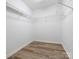 This walk-in closet has wire shelving, wood-look floors, and neutral walls at 1203 Maple Shade Ln, Charlotte, NC 28270