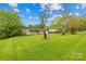 Landscaped front yard featuring a charming single-story home with blue and brick accents at 1204 Meadowood Dr, Shelby, NC 28150