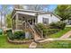 Home with a covered porch, stairway, and beautifully landscaped yard at 132 Larboard Trl, Mount Gilead, NC 27306